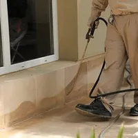 General pest control technician spraying exterior perimeter around a home in New Haven, CT